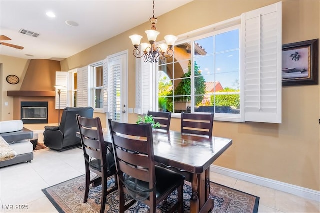 12276 Caminita Pl, Las Vegas, NV 89138 - dining room with light tile patterned floors, a chandelier, a fireplace, and ceiling fan