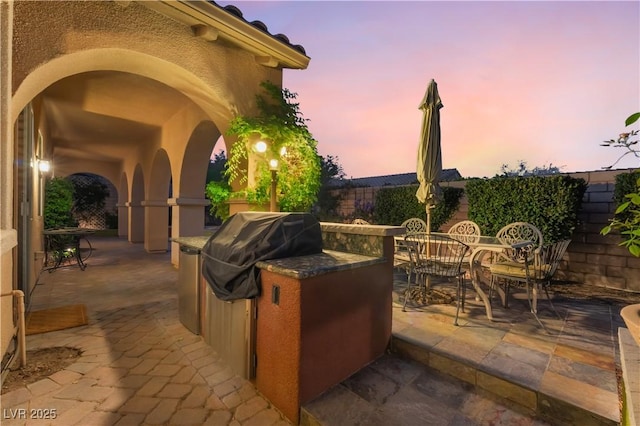 12276 Caminita Pl, Las Vegas, NV 89138 - patio terrace at dusk with exterior kitchen, a patio area, and outdoor dining space