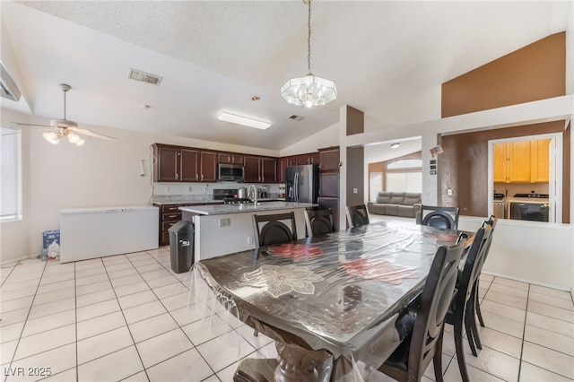 6224 Mandarin Dr, Las Vegas, NV 89108 - dining area with independent washer and dryer, vaulted ceiling, light tile patterned floors, a chandelier, and ceiling fan