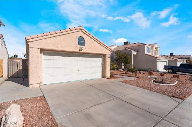 6224 Mandarin Dr, Las Vegas, NV 89108 - view of front of property featuring a garage, stucco siding, a tiled roof, and a gate