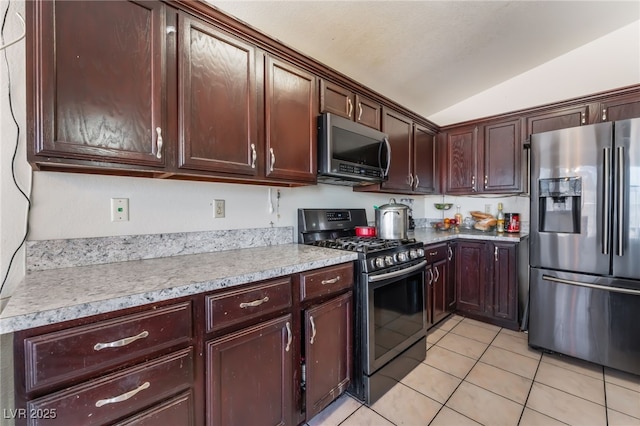 6224 Mandarin Dr, Las Vegas, NV 89108 - kitchen with appliances with stainless steel finishes, lofted ceiling, light tile patterned flooring, light countertops, and dark brown cabinets