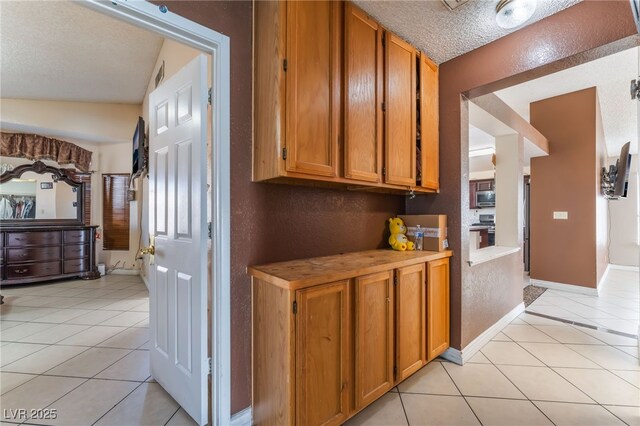 6224 Mandarin Dr, Las Vegas, NV 89108 - corridor featuring light tile patterned floors, a textured wall, and a textured ceiling