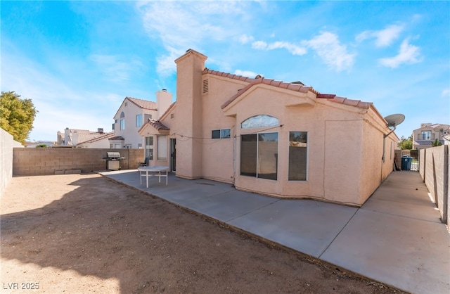 6224 Mandarin Dr, Las Vegas, NV 89108 - rear view of property with a tiled roof, a patio area, a fenced backyard, stucco siding, and a chimney