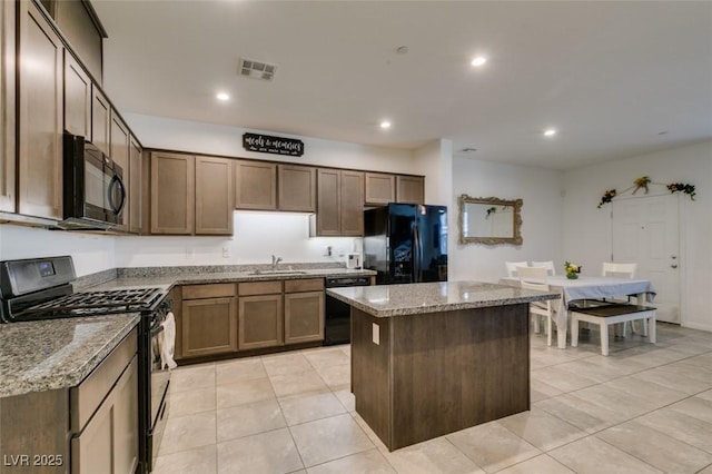 1200 Mission View Ct, Henderson, NV 89002 - kitchen featuring black appliances, a center island, light tile patterned flooring, light stone countertops, and recessed lighting