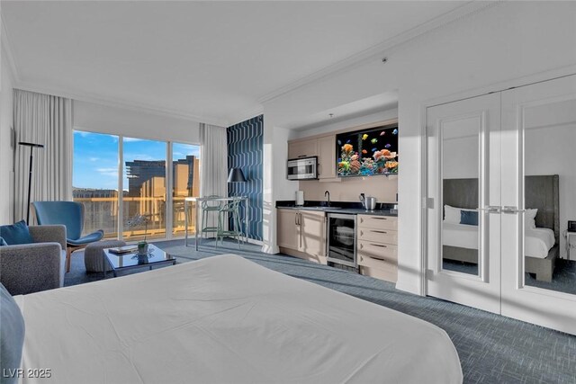 145 E Harmon Ave Unit 3705, Las Vegas, NV 89109 - bedroom with beverage cooler, wet bar, crown molding, carpet, and access to exterior