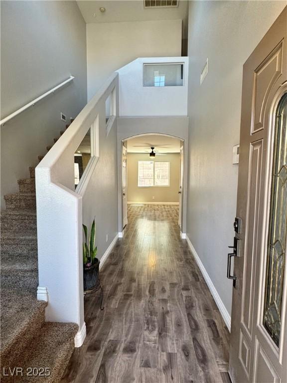 9165 Beauchamp Ave, Las Vegas, NV 89148 - entrance foyer with arched walkways, wood finished floors, stairs, and a towering ceiling