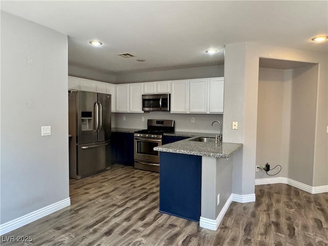 9165 Beauchamp Ave, Las Vegas, NV 89148 - kitchen with appliances with stainless steel finishes, white cabinetry, a peninsula, dark wood-type flooring, and recessed lighting