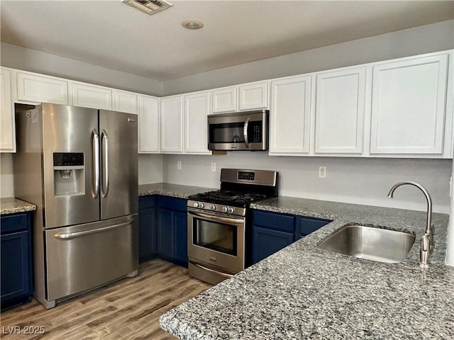 9165 Beauchamp Ave, Las Vegas, NV 89148 - kitchen with stainless steel appliances, blue cabinets, and white cabinetry