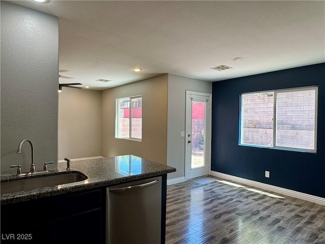 9165 Beauchamp Ave, Las Vegas, NV 89148 - kitchen with stainless steel dishwasher, wood finished floors, dark stone countertops, a ceiling fan, and recessed lighting