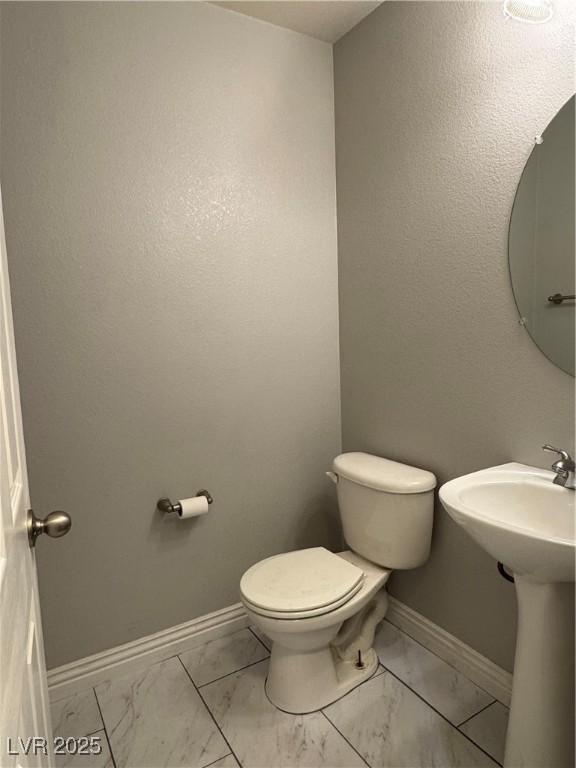 9165 Beauchamp Ave, Las Vegas, NV 89148 - half bathroom featuring marble look tile flooring and toilet