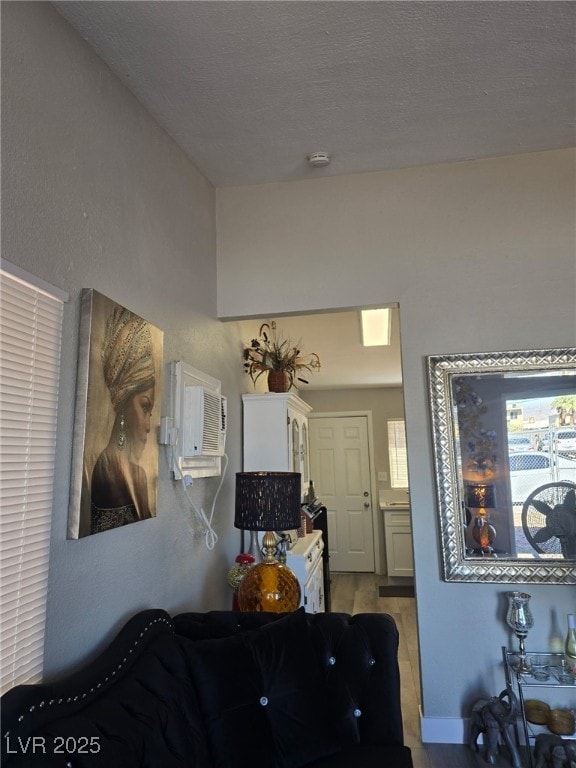 1713 Fairfield Ave, Las Vegas, NV 89102 - living room with a wall mounted air conditioner, wood finished floors, and a textured ceiling