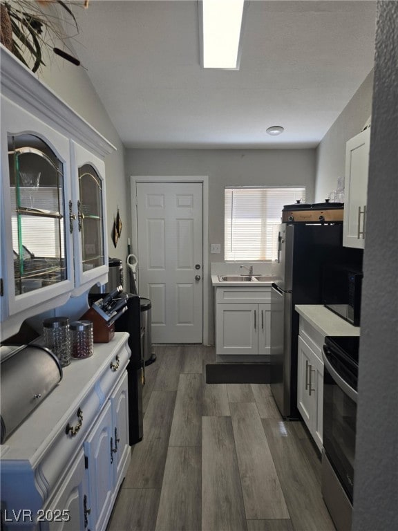 1713 Fairfield Ave, Las Vegas, NV 89102 - kitchen with stainless steel electric stove, black microwave, dark wood-style floors, light countertops, and white cabinets
