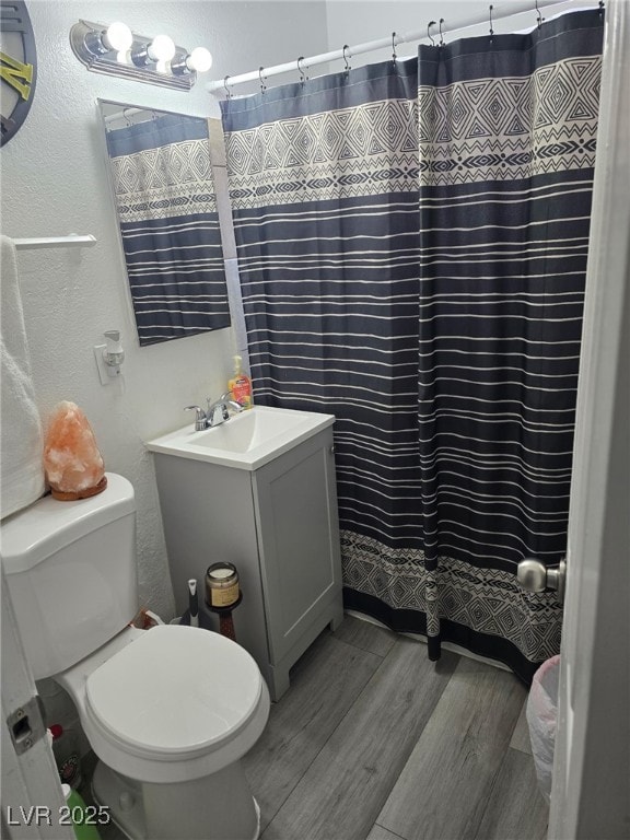 1713 Fairfield Ave, Las Vegas, NV 89102 - full bath featuring a textured wall, wood finished floors, vanity, and a shower with shower curtain
