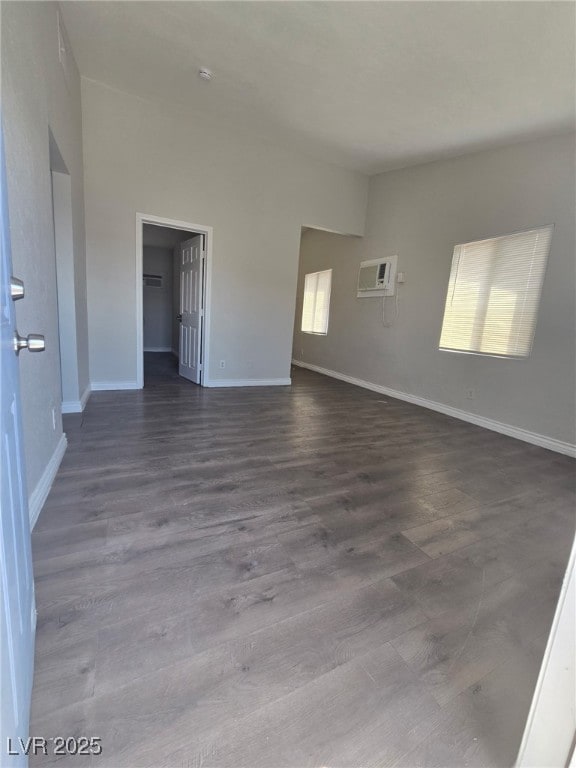 1713 Fairfield Ave, Las Vegas, NV 89102 - unfurnished room with dark wood-style flooring, a wall unit AC, and a smoke detector