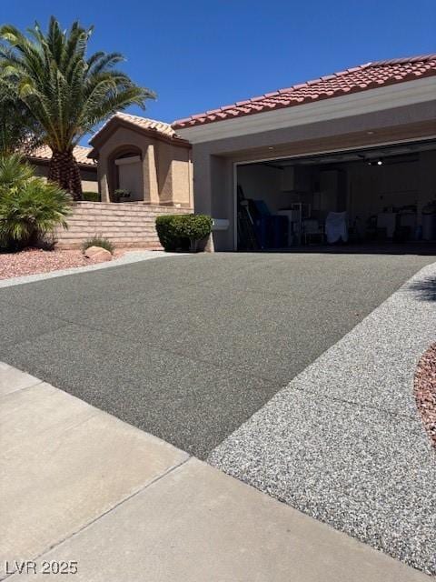 10036 Keysborough Dr, Las Vegas, NV 89134 - view of front of property featuring a tile roof, stucco siding, a garage, and driveway