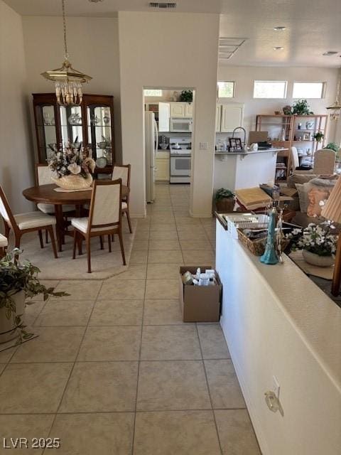 10036 Keysborough Dr, Las Vegas, NV 89134 - dining room with light tile patterned floors and a chandelier