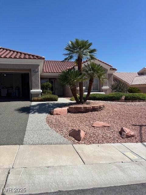 10036 Keysborough Dr, Las Vegas, NV 89134 - view of front of property featuring a tile roof, an attached garage, driveway, and stucco siding