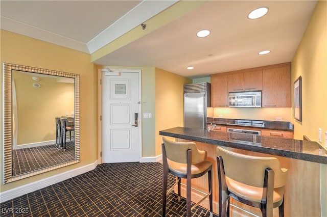 2000 Fashion Show Dr Unit 4105-4106, Las Vegas, NV 89109 - kitchen with appliances with stainless steel finishes, a kitchen breakfast bar, recessed lighting, brown cabinetry, and dark carpet