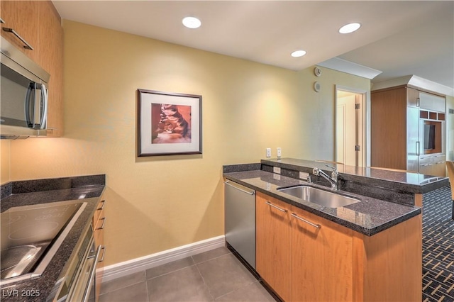 2000 Fashion Show Dr Unit 4105-4106, Las Vegas, NV 89109 - kitchen featuring stainless steel appliances, a peninsula, dark stone counters, brown cabinets, and tile patterned flooring