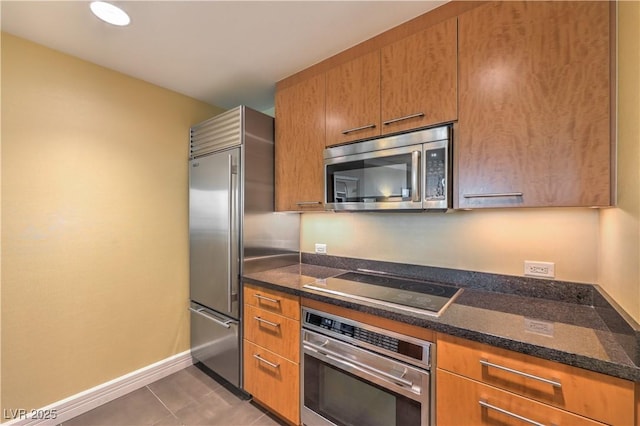 2000 Fashion Show Dr Unit 4105-4106, Las Vegas, NV 89109 - kitchen with stainless steel appliances, tile patterned flooring, brown cabinetry, and dark stone countertops