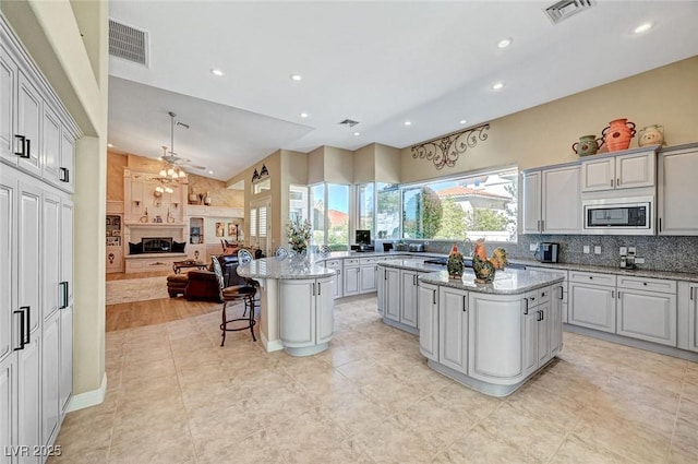 4936 Mountain Foliage Dr, Las Vegas, NV 89148 - kitchen featuring stainless steel microwave, a center island, decorative backsplash, recessed lighting, and open floor plan