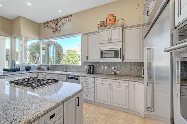 4936 Mountain Foliage Dr, Las Vegas, NV 89148 - kitchen featuring appliances with stainless steel finishes, tasteful backsplash, recessed lighting, light stone countertops, and light tile patterned floors