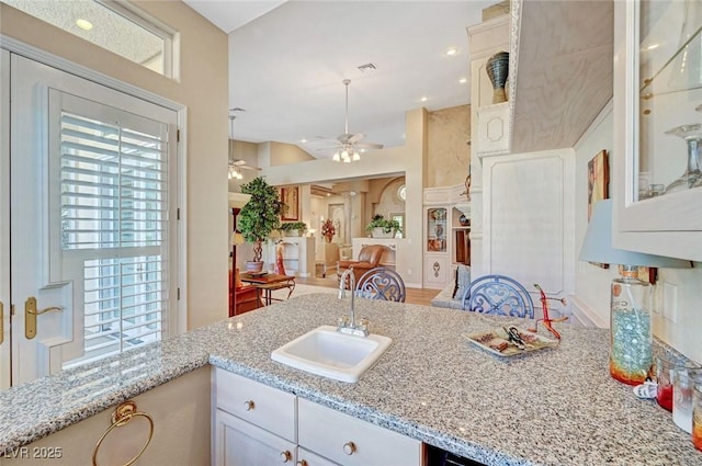 4936 Mountain Foliage Dr, Las Vegas, NV 89148 - kitchen featuring light stone counters, glass insert cabinets, white cabinets, ceiling fan, and recessed lighting