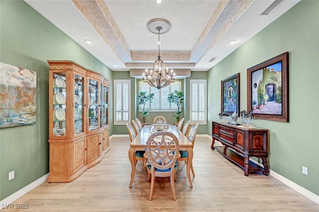 4936 Mountain Foliage Dr, Las Vegas, NV 89148 - dining space with a chandelier, a tray ceiling, and light wood-style floors