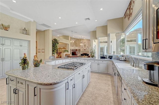4936 Mountain Foliage Dr, Las Vegas, NV 89148 - kitchen featuring appliances with stainless steel finishes, light stone countertops, a peninsula, a kitchen island, and open floor plan
