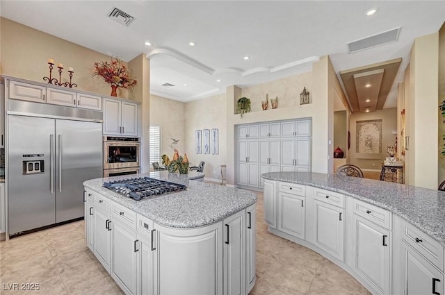 4936 Mountain Foliage Dr, Las Vegas, NV 89148 - kitchen with appliances with stainless steel finishes, recessed lighting, a center island, light stone countertops, and light tile patterned floors