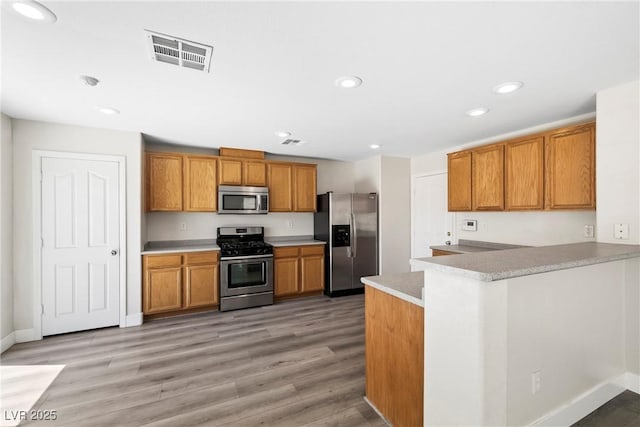 5824 Gemstone Peak St, North Las Vegas, NV 89031 - kitchen featuring appliances with stainless steel finishes, brown cabinetry, recessed lighting, and light countertops