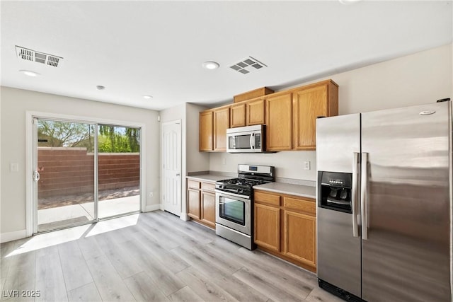 5824 Gemstone Peak St, North Las Vegas, NV 89031 - kitchen featuring appliances with stainless steel finishes, light countertops, light wood-type flooring, recessed lighting, and brown cabinetry