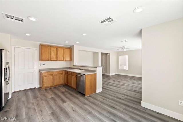 5824 Gemstone Peak St, North Las Vegas, NV 89031 - kitchen featuring a peninsula, stainless steel appliances, light countertops, ceiling fan, and light wood finished floors