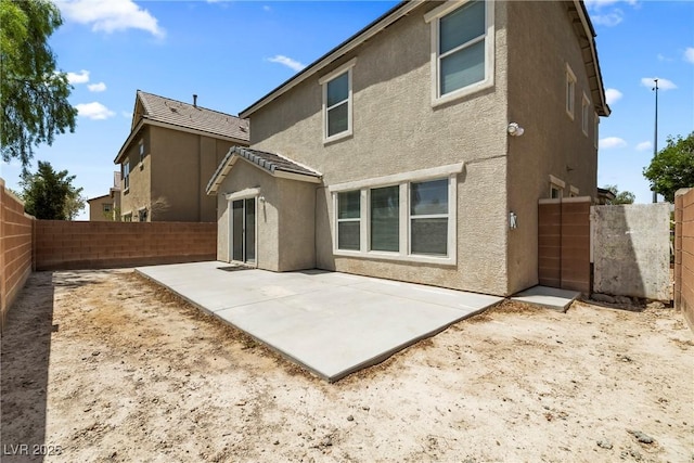5824 Gemstone Peak St, North Las Vegas, NV 89031 - rear view of property featuring stucco siding, a fenced backyard, and a patio