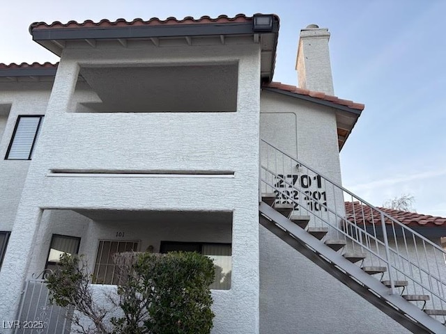 2701 Beaver Creek Ct Unit 201, Las Vegas, NV 89117 - view of home's exterior featuring stairs, a tiled roof, and stucco siding