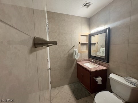 2701 Beaver Creek Ct Unit 201, Las Vegas, NV 89117 - bathroom featuring tile walls, vanity, and tile patterned floors