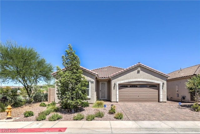 326 Zenith Crest St, Henderson, NV 89015 - view of front of home with a garage, decorative driveway, stucco siding, and a tile roof