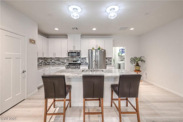 326 Zenith Crest St, Henderson, NV 89015 - kitchen with appliances with stainless steel finishes, tasteful backsplash, white cabinetry, a kitchen breakfast bar, and recessed lighting