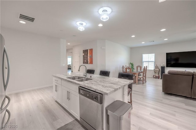 326 Zenith Crest St, Henderson, NV 89015 - kitchen featuring appliances with stainless steel finishes, open floor plan, a kitchen island with sink, white cabinets, and light wood-style flooring