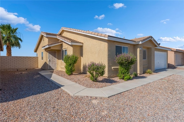 2111 Hollow Oak Ave, North Las Vegas, NV 89031 - ranch-style home with stucco siding, a garage, and a tile roof