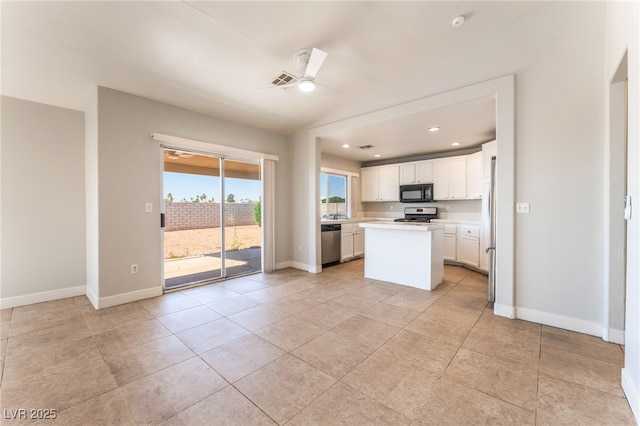 2111 Hollow Oak Ave, North Las Vegas, NV 89031 - kitchen with appliances with stainless steel finishes, light countertops, a ceiling fan, white cabinets, and a center island