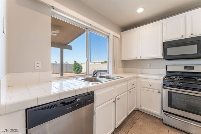2111 Hollow Oak Ave, North Las Vegas, NV 89031 - kitchen with stainless steel appliances, tile countertops, white cabinetry, recessed lighting, and light tile patterned floors