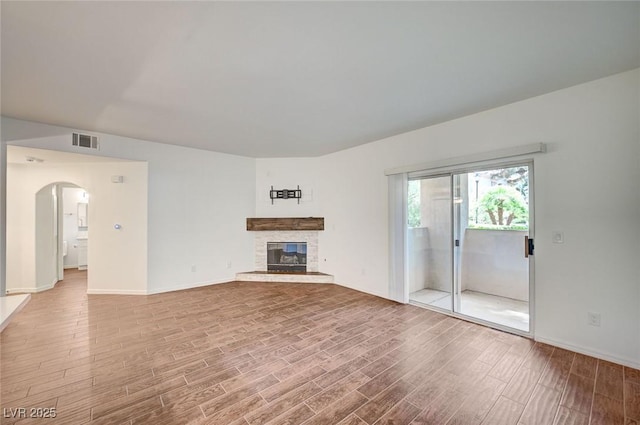 2050 W Warm Springs Rd Unit 4512, Henderson, NV 89014 - unfurnished living room with wood finished floors, a fireplace, and arched walkways