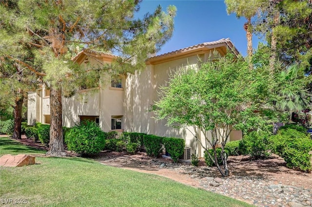 2050 W Warm Springs Rd Unit 4512, Henderson, NV 89014 - view of side of property with stucco siding, a yard, and a tiled roof