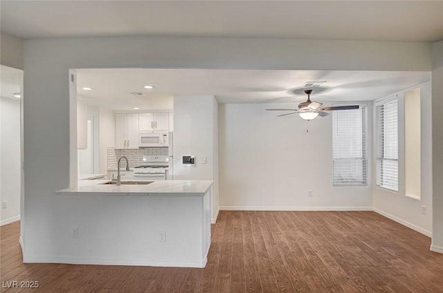 2050 W Warm Springs Rd Unit 4512, Henderson, NV 89014 - kitchen featuring white appliances, white cabinetry, backsplash, light countertops, and wood finished floors