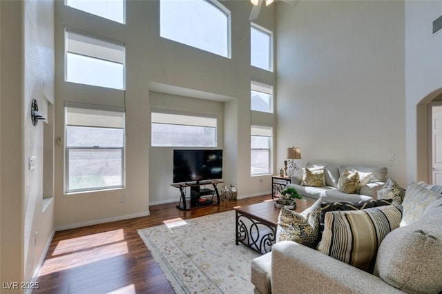 10952 Porto Foxi St, Las Vegas, NV 89141 - living room featuring a high ceiling, arched walkways, wood finished floors, and ceiling fan