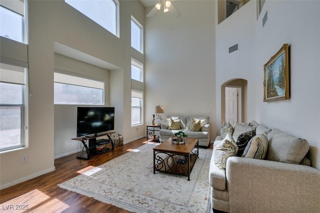 10952 Porto Foxi St, Las Vegas, NV 89141 - living room with a towering ceiling, arched walkways, ceiling fan, and wood finished floors