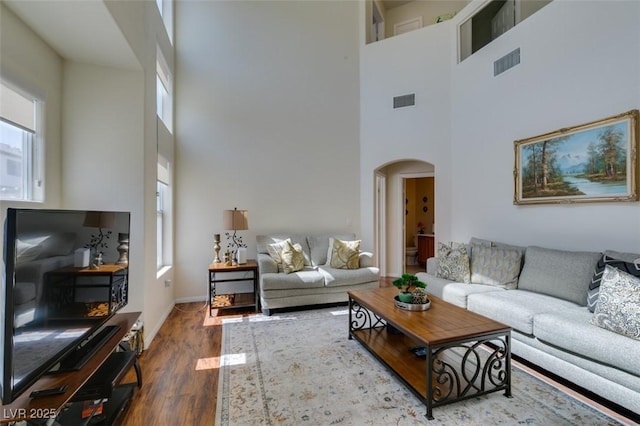 10952 Porto Foxi St, Las Vegas, NV 89141 - living room with arched walkways, healthy amount of natural light, a high ceiling, and wood finished floors