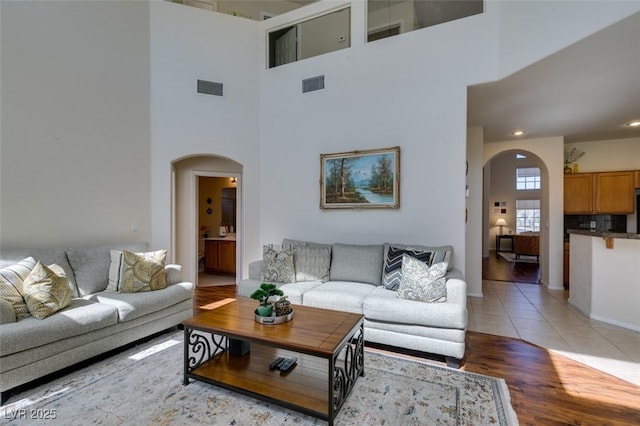10952 Porto Foxi St, Las Vegas, NV 89141 - living area featuring arched walkways, a high ceiling, light wood finished floors, and recessed lighting