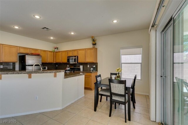 10952 Porto Foxi St, Las Vegas, NV 89141 - kitchen featuring stainless steel appliances, decorative backsplash, a breakfast bar area, recessed lighting, and light tile patterned floors